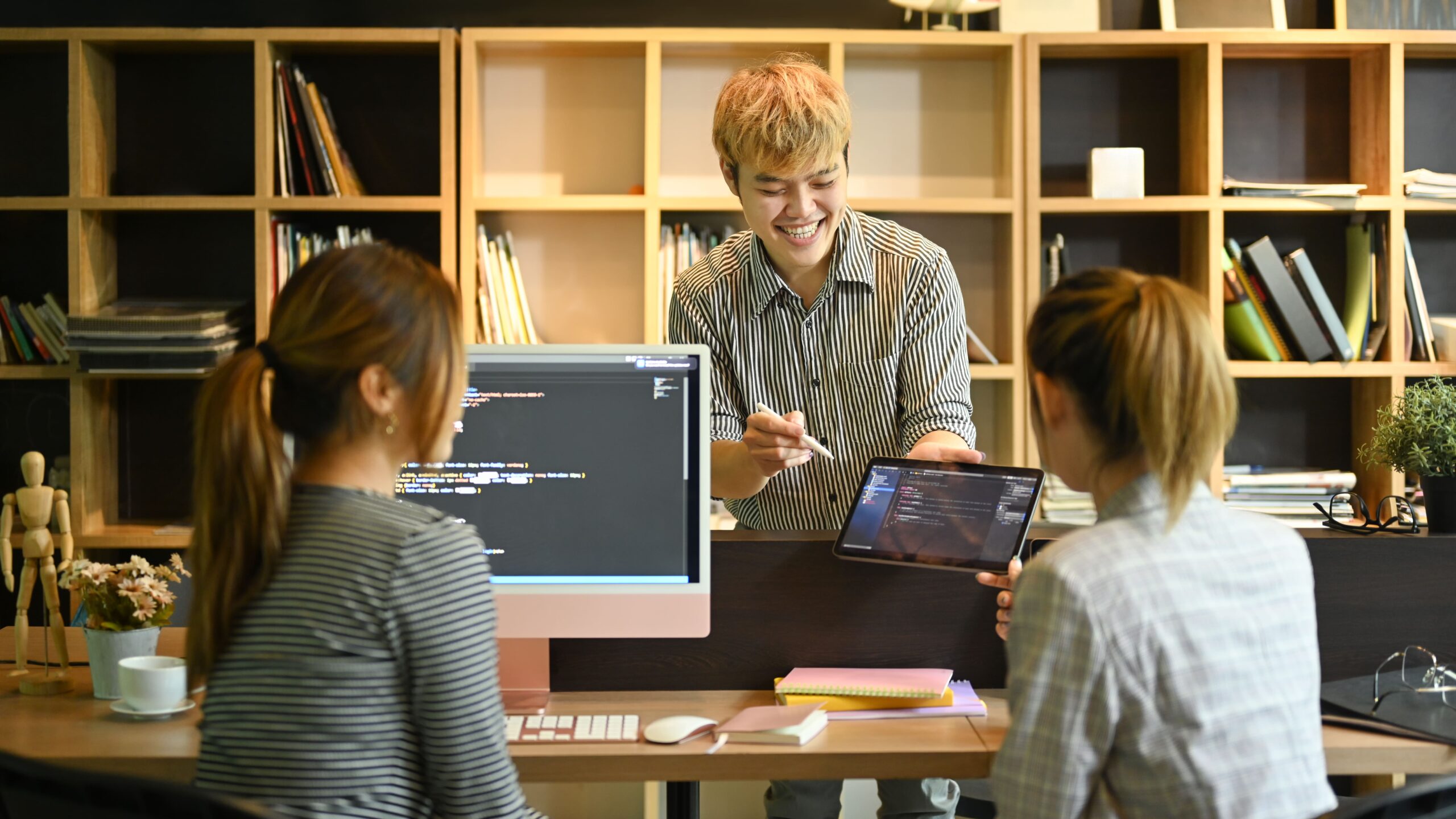 Equipo de jóvenes especialistas que crean software innovador, trabajando juntos en un lugar de trabajo contemporáneo.