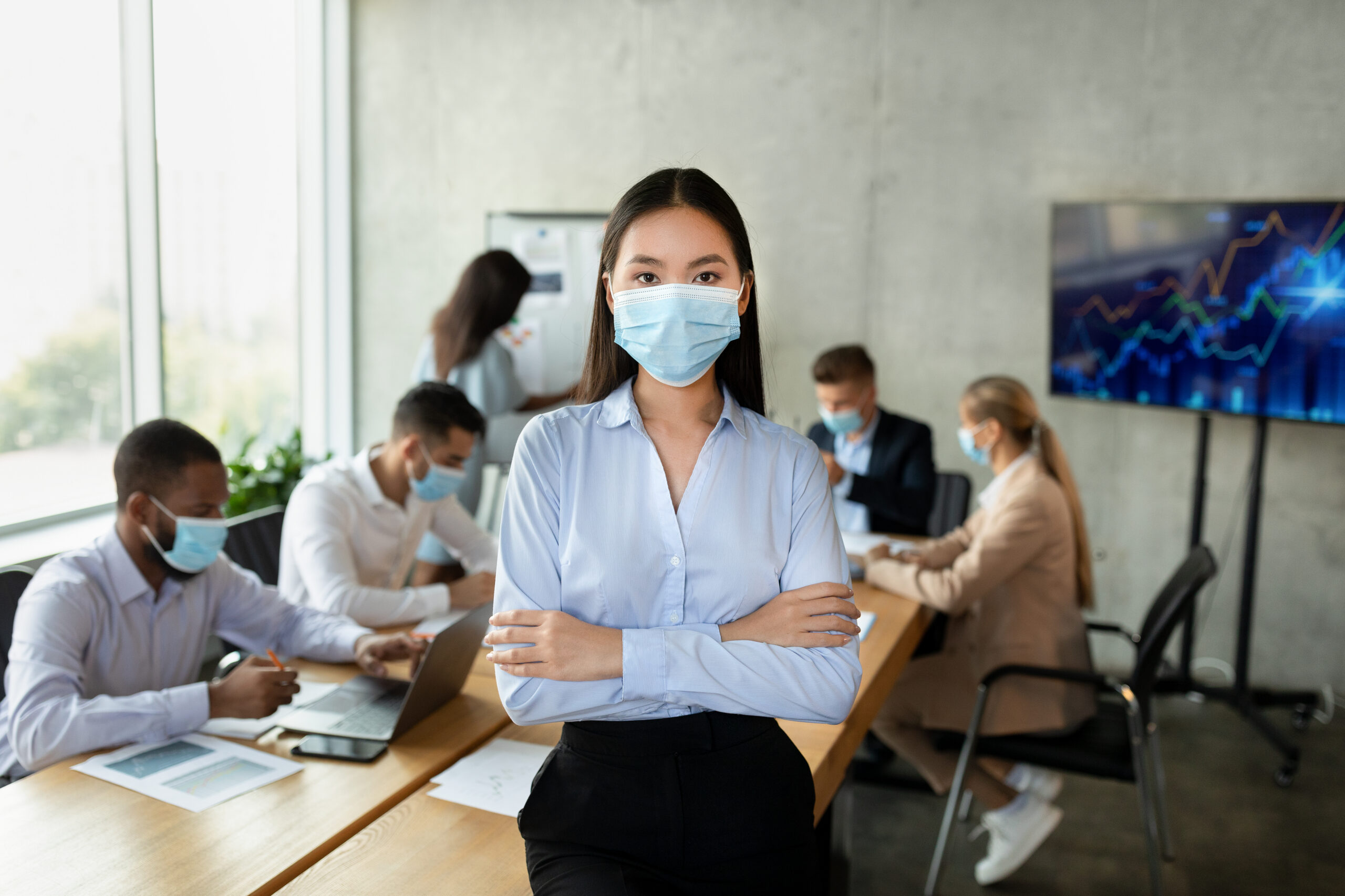 Personas con mascarillas en una sala de reuniones