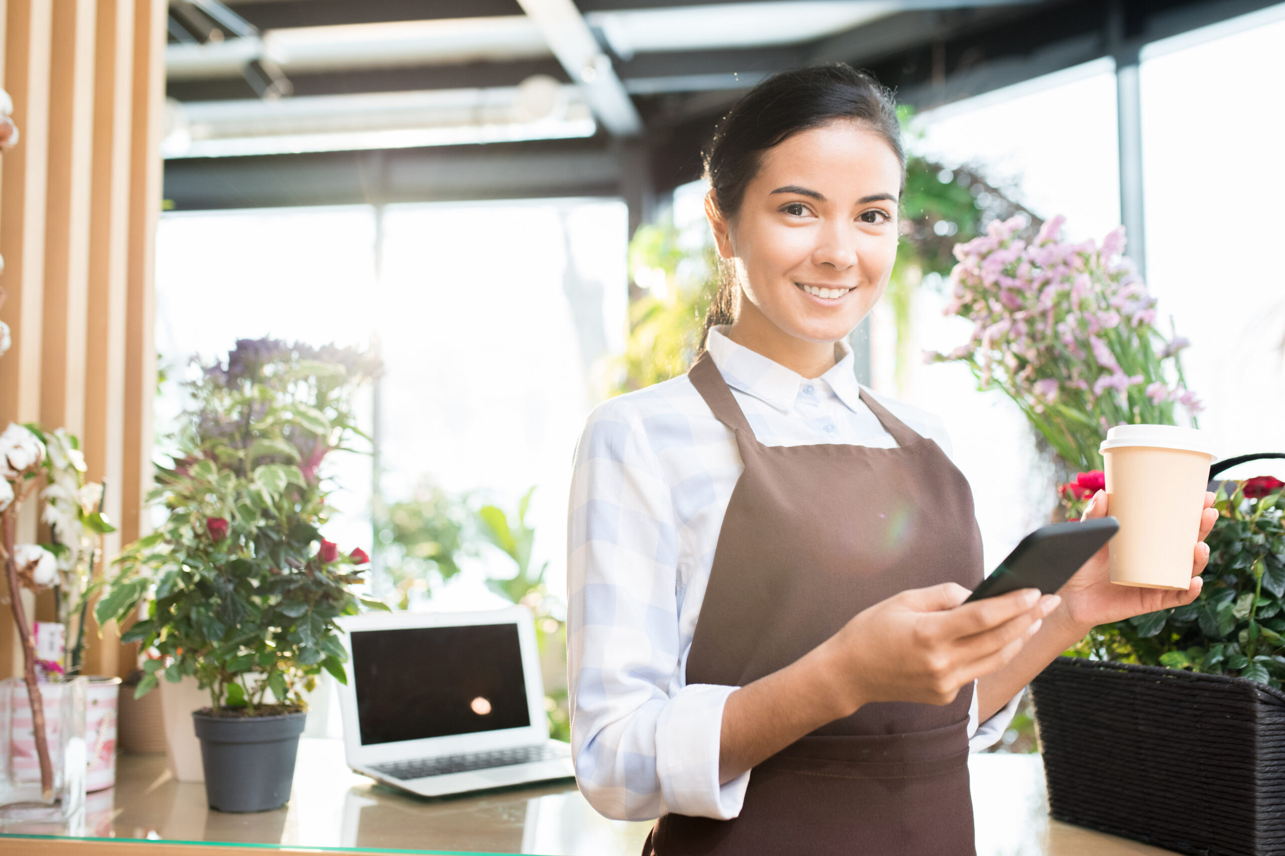 Asistente de cafetería con su celular
