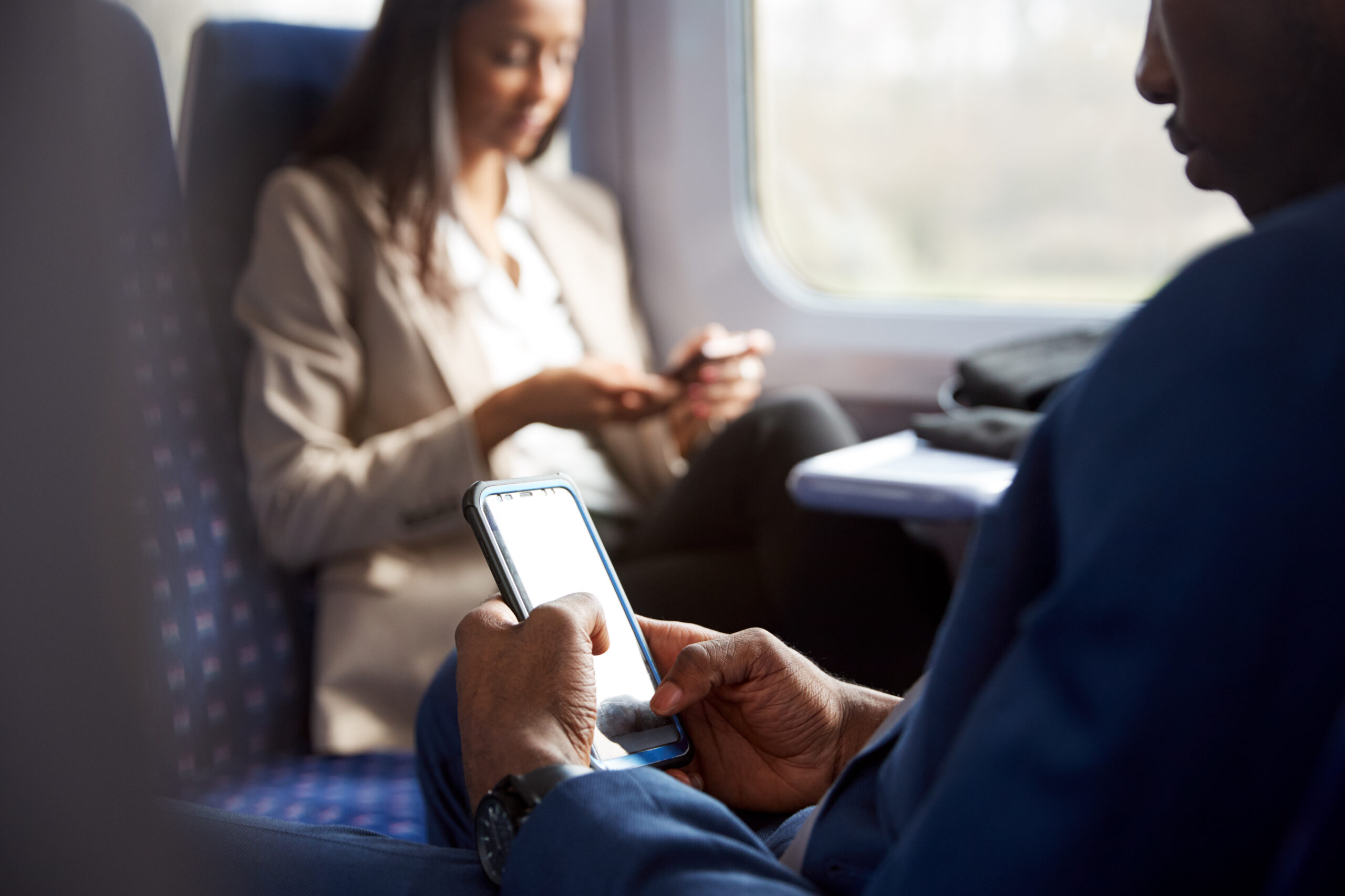 Cerca De Los Pasajeros De Negocios Sentados En Tren De Viaje Para Trabajo Mirando Los Teléfonos Móvil viles